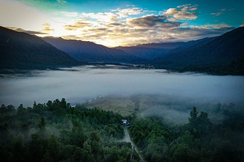 An aerial view of a valley covered in fog.