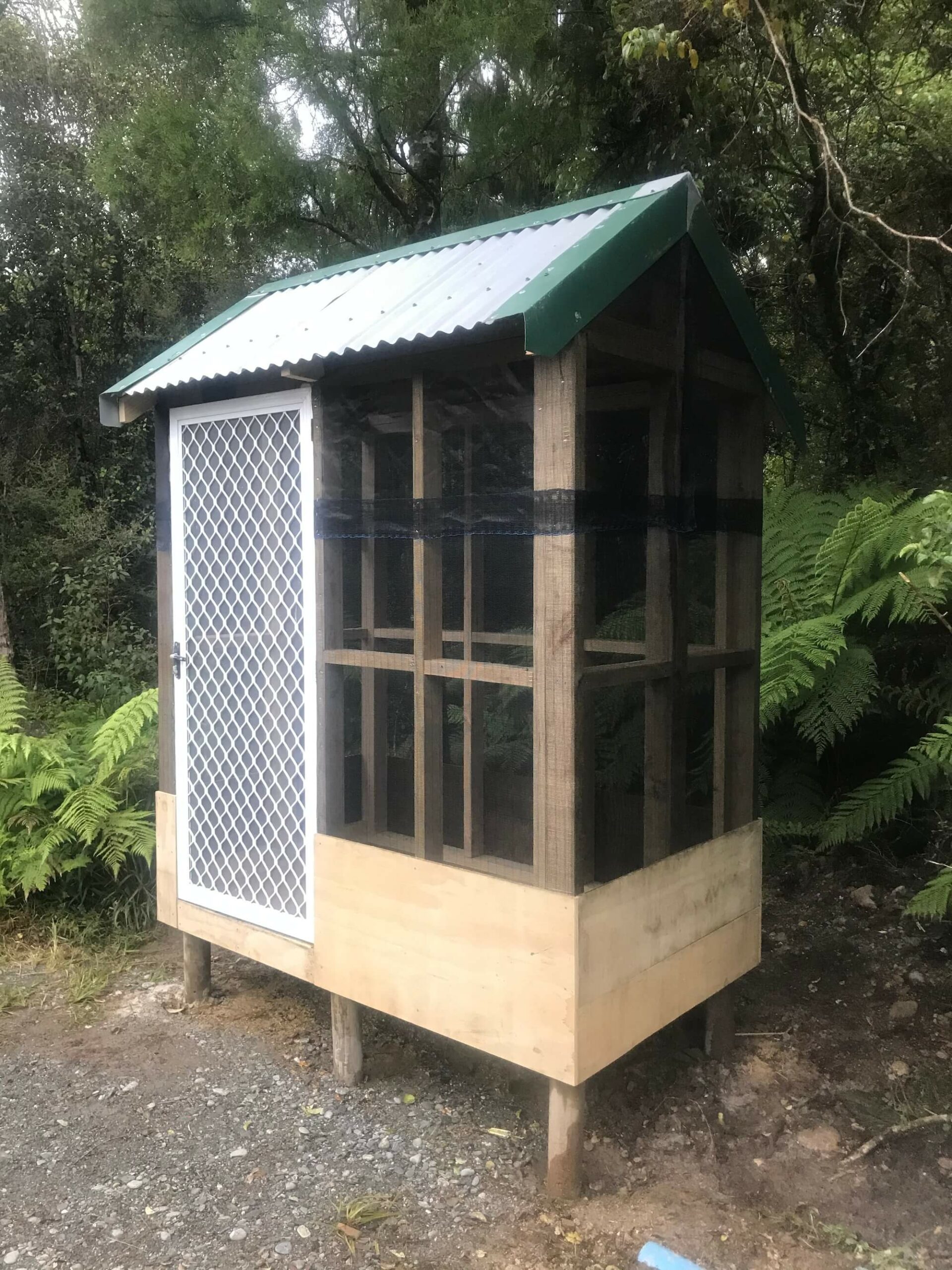 A chicken coop with a window and a door.